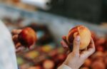 Person choosing peaches in a food market