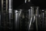 Glass measuring beakers and conical flasks on a black background